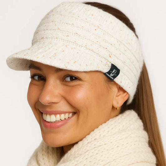 Studio close-up of woman in white ponytail beanie hat smiling