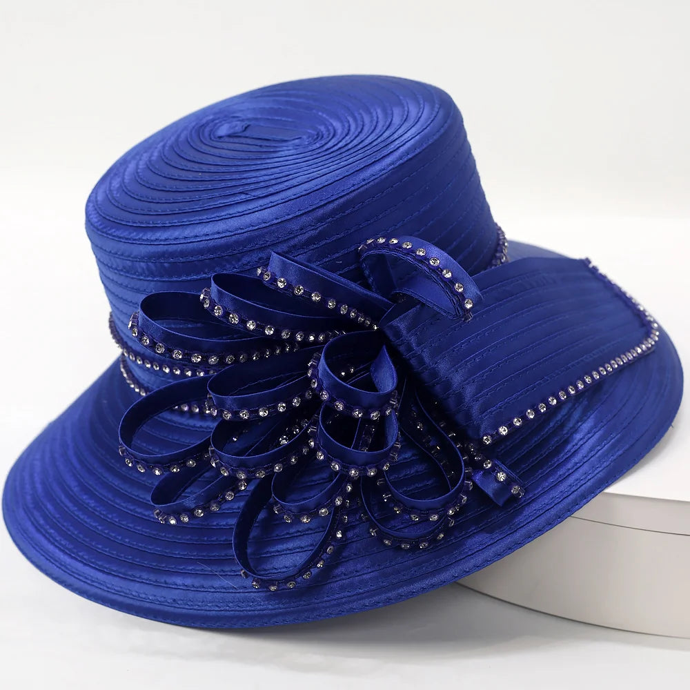 Rear angle of a royal blue satin church hat featuring sparkling rhinestones and elaborate ribbon bow design — ideal for formal occasions and Sunday service.