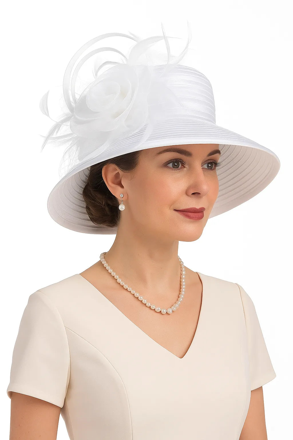 White elegant church hat with large flower for wedding guest or formal events – worn by model in ivory dress with pearl jewelry