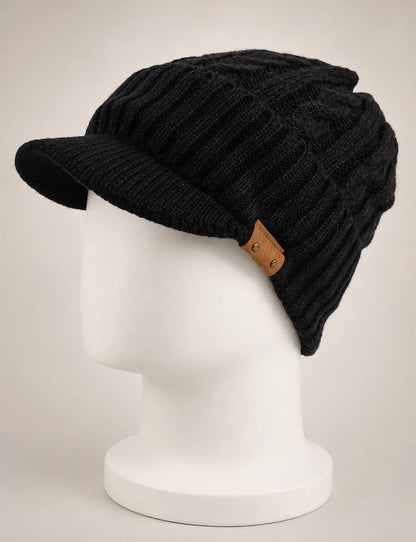 Black cable knit visor beanie B5042 with a soft brim and brown side detail on a white mannequin.