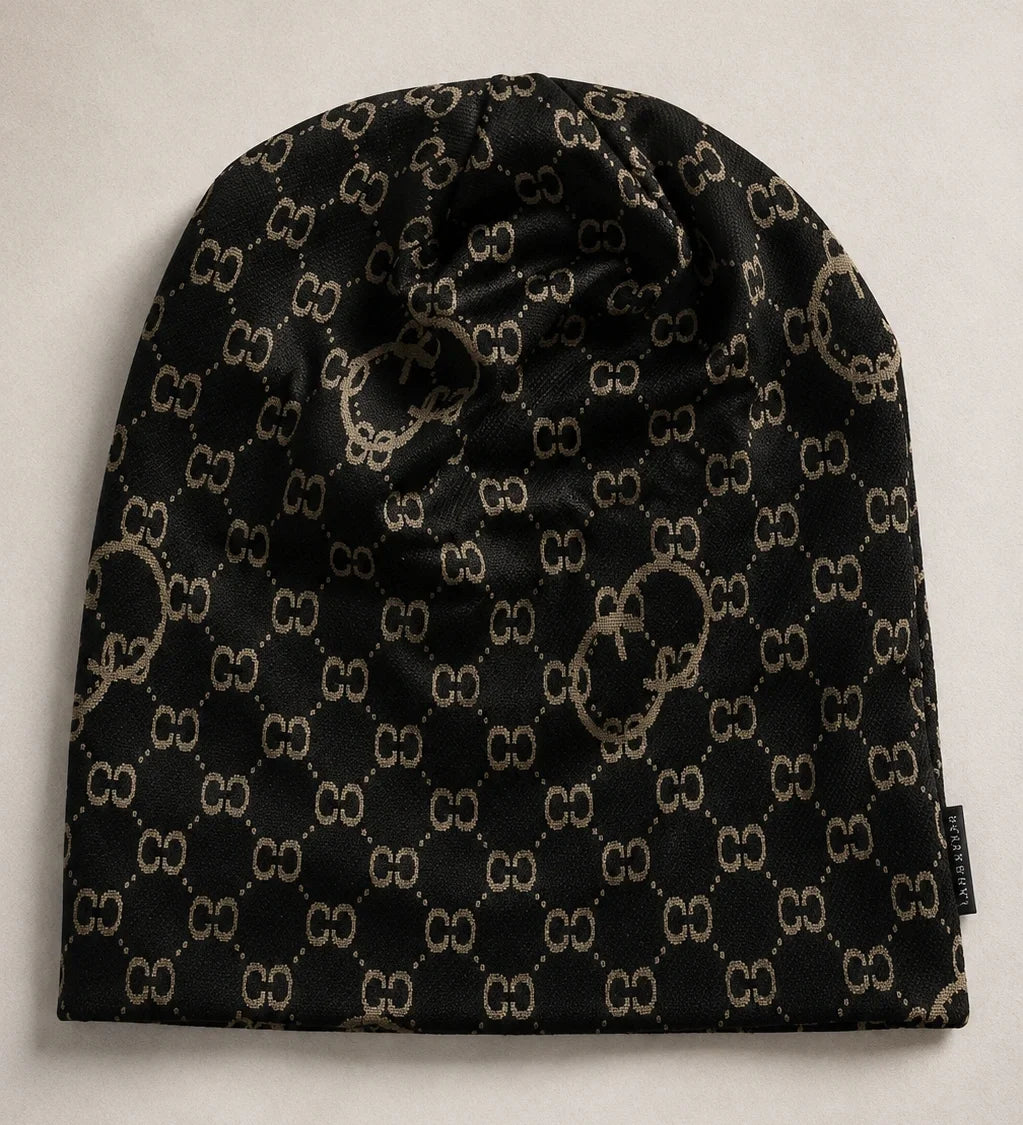 Flat lay of black slouchy beanie cap with vintage-inspired CC print, oversized knit hat for men and women, suitable for all-year wear.
