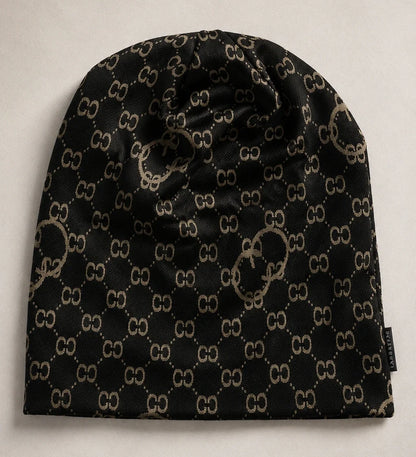 Flat lay of black slouchy beanie cap with vintage-inspired CC print, oversized knit hat for men and women, suitable for all-year wear.