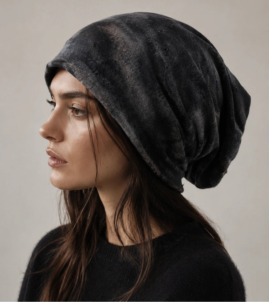 Black slouchy beanie on female model, side profile showing long relaxed fit, distressed texture and modern everyday style