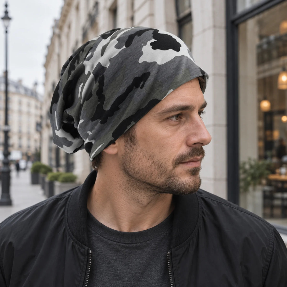 Man wearing a black and white camo slouchy beanie on a city street