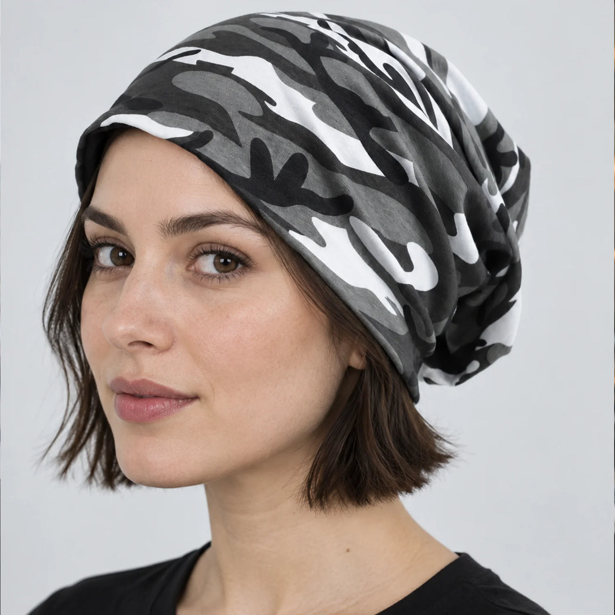 Woman wearing a black and white camo slouchy beanie in a studio