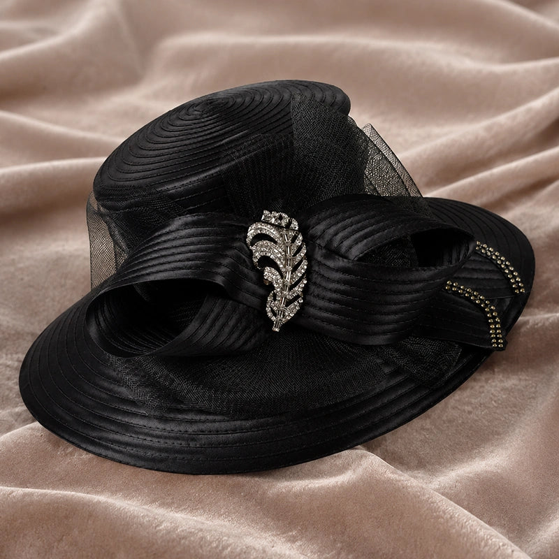 Black wide brim church hat with rhinestone embellishment and mesh ribbon detail displayed on velvet fabric background