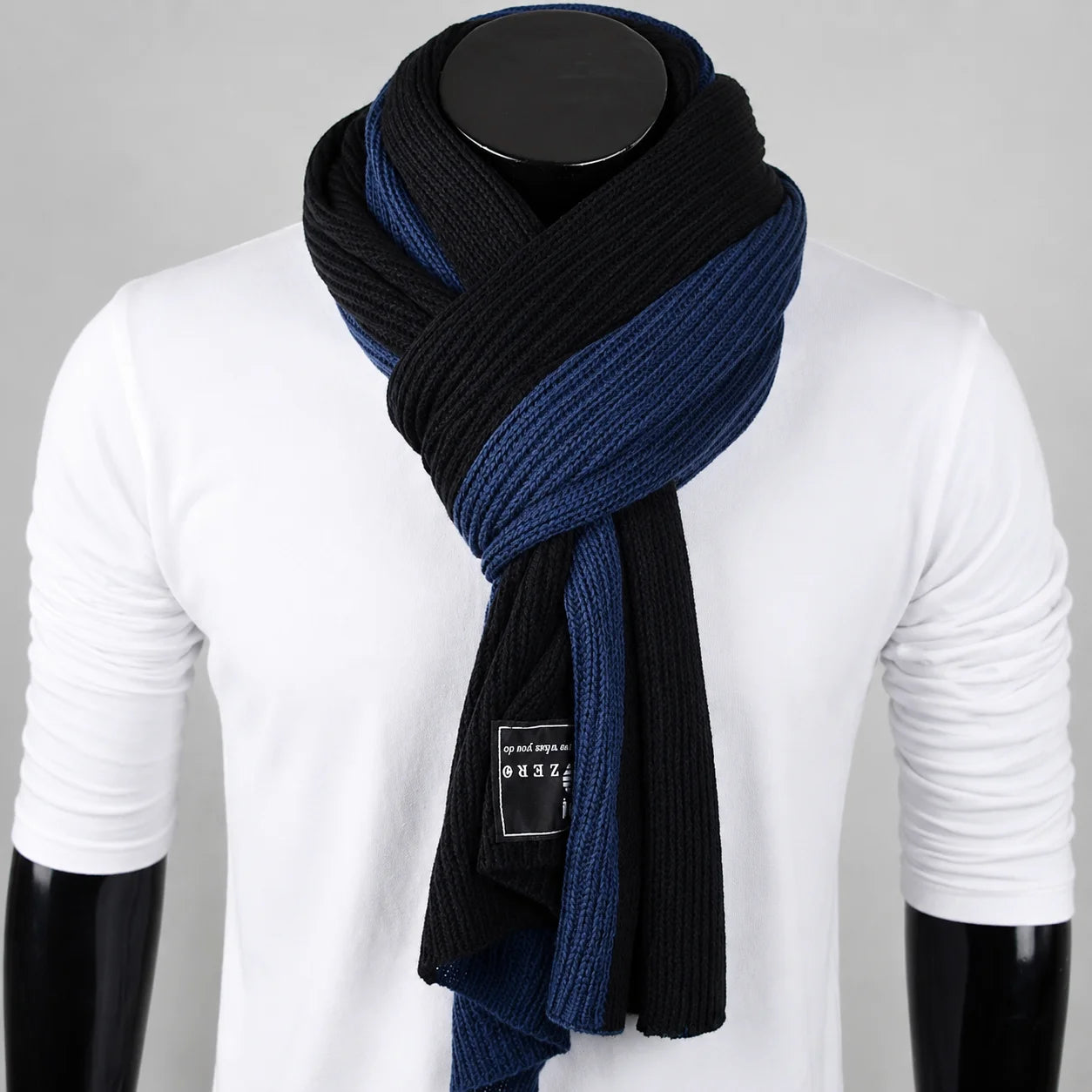 Blue and black melange knit scarf on mannequin, ribbed texture with modern contrast design for urban winter styling