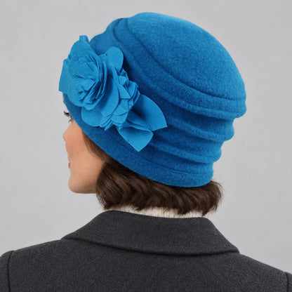 Rear side view of a bright blue brimless wool cloche hat showing layered crown ruching