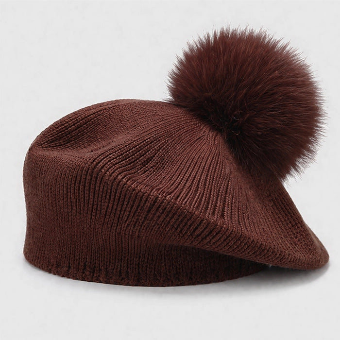 Brown beret with pom-pom, adding style to your winter wardrobe. Soft, knitted design for comfort.