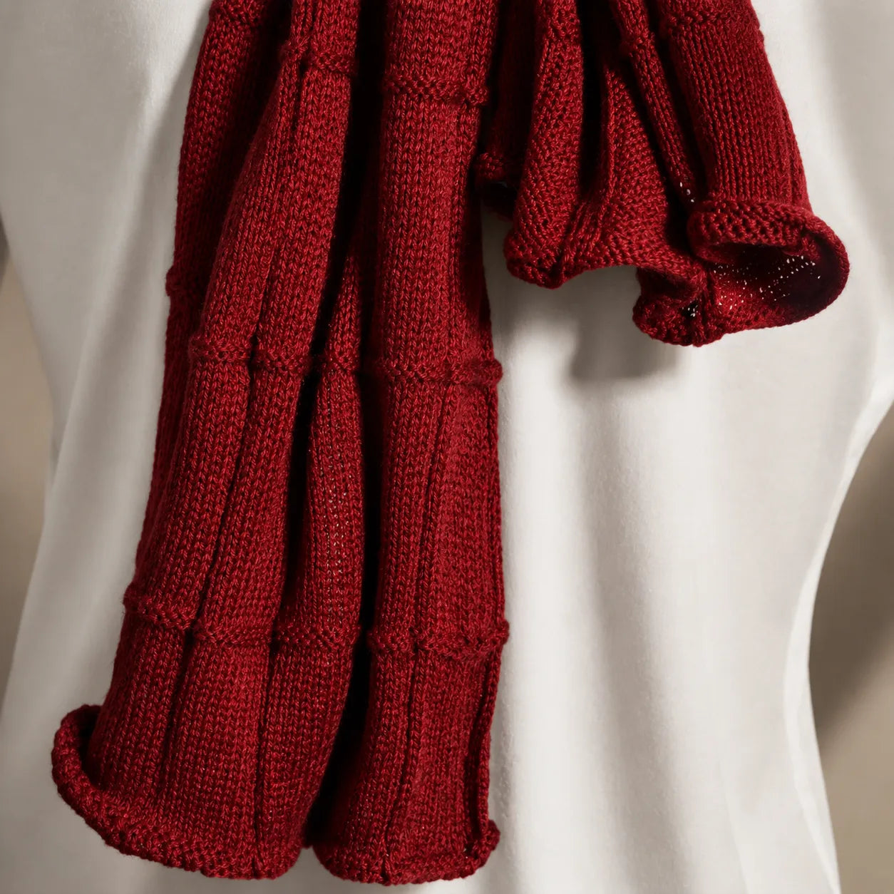 Close-up claret red knit scarf texture, soft warm winter knitwear, premium unisex scarf fabric detail for luxury cold weather fashion