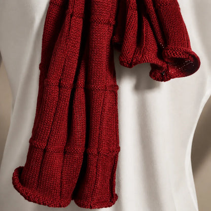 Close-up claret red knit scarf texture, soft warm winter knitwear, premium unisex scarf fabric detail for luxury cold weather fashion