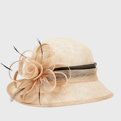 Stylish beige cloche sinamay hat with a sophisticated black ribbon and flower accent, designed for elegant afternoon events or garden parties.