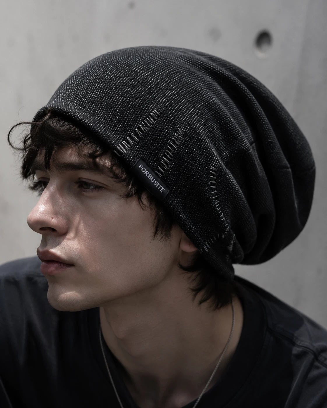 Close-up of black slouchy beanie for men featuring soft lightweight knit fabric and modern casual street fashion look