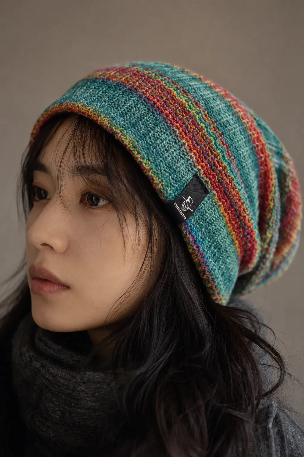 Close up portrait of woman wearing colorful knit slouchy beanie with soft textured fabric