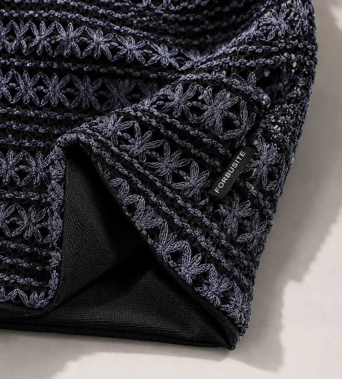 Close up detail of crochet knit slouchy beanie texture showing floral stitch craftsmanship and soft fabric