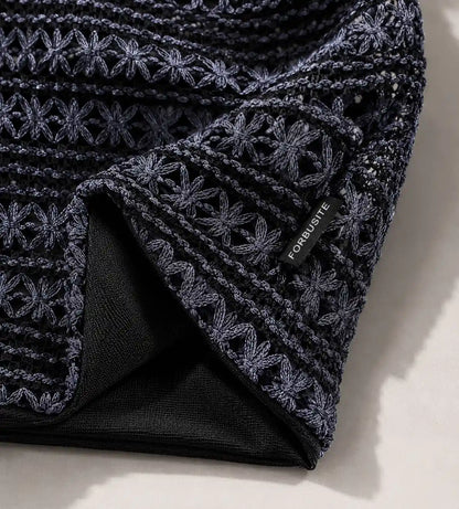 Close up detail of crochet knit slouchy beanie texture showing floral stitch craftsmanship and soft fabric