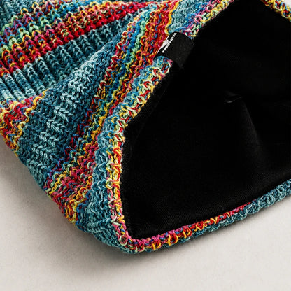 Close up detail of colorful rainbow knit beanie showing soft yarn texture and craftsmanship