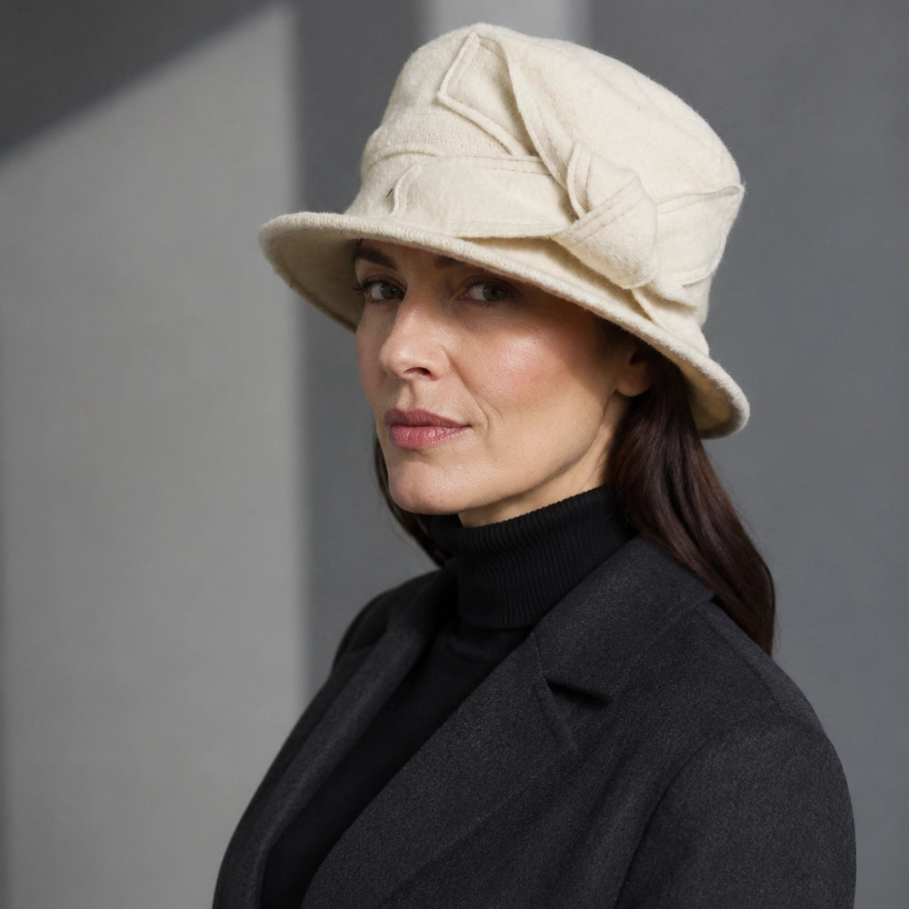 Woman wearing a cream wool felt cloche hat with side bow