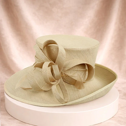 Elegant apricot wedding hat with decorative satin ribbons, a perfect accessory for formal events