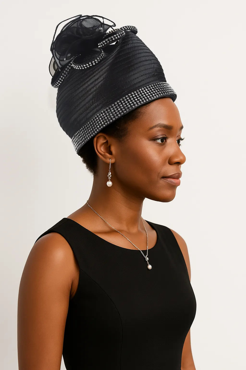 Luxury black satin pillbox hat with floral accents and crystal embellishments. A formal hat ideal for weddings, church services, or tea parties, offering a sophisticated vintage look.