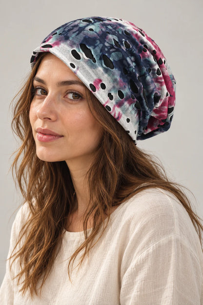 Woman wearing the blue and pink B077 slouchy beanie in a three-quarter view, showing the cutouts and soft drape.