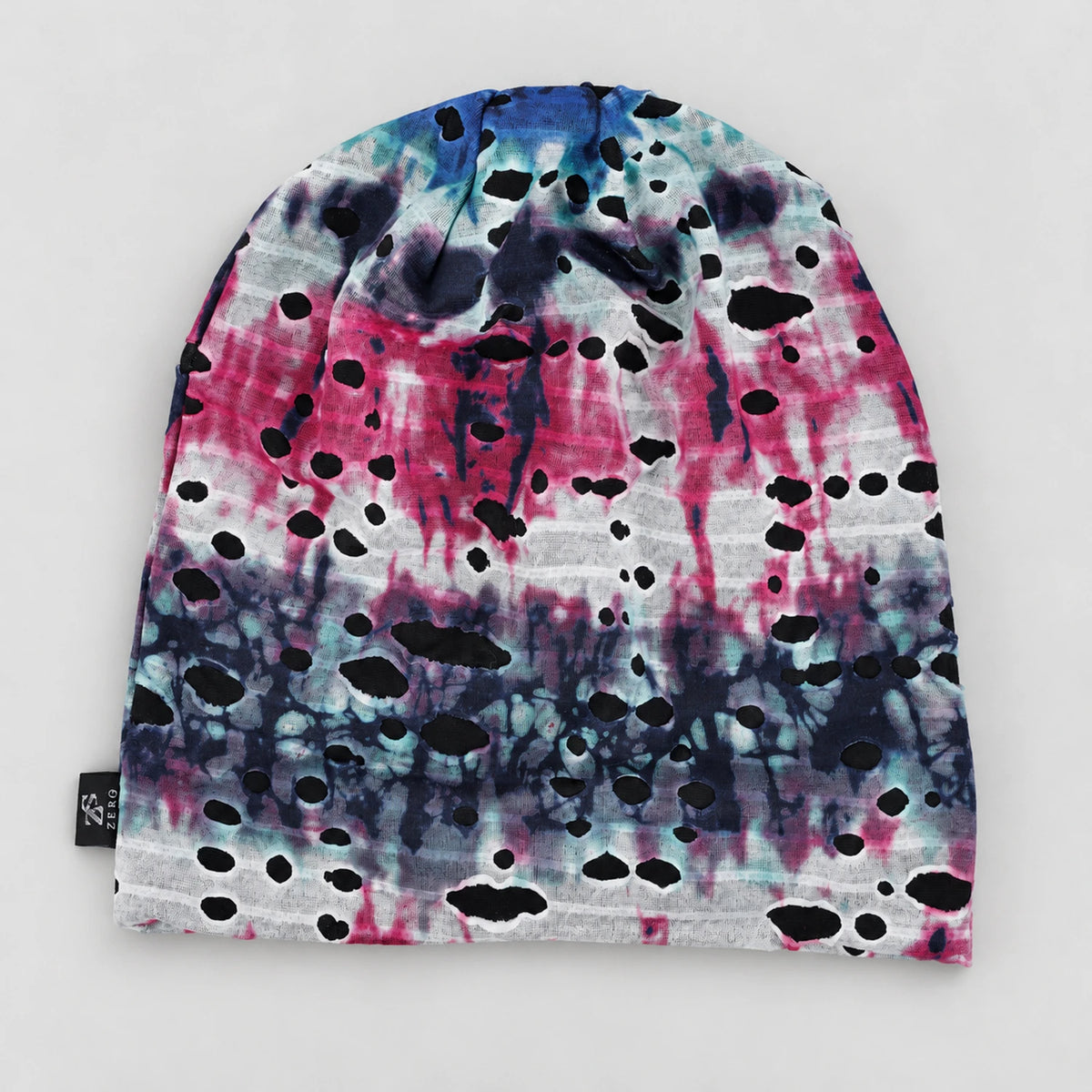 Flat front view of the blue and pink B077 beanie with white areas and black mesh visible through the cutouts.