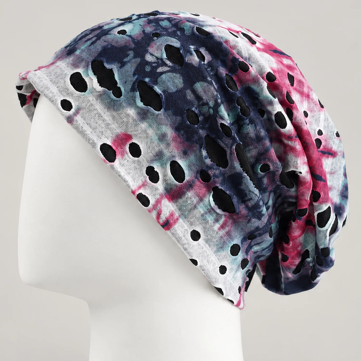 Blue, pink and white tie-dye B077 slouchy beanie on a white mannequin, showing the cutout pattern and back drape.