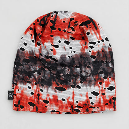 Flat front view of the red, black and white B077 beanie, showing the tie-dye bands and distressed cutout detail.