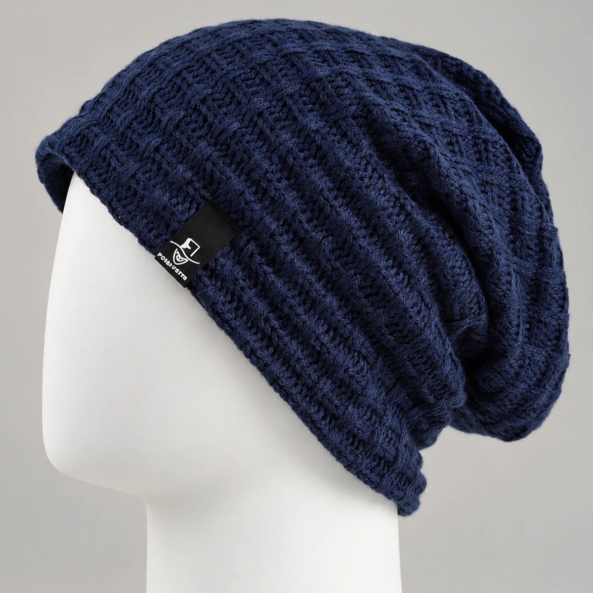 Navy knit slouchy beanie with textured openwork pattern on a mannequin head