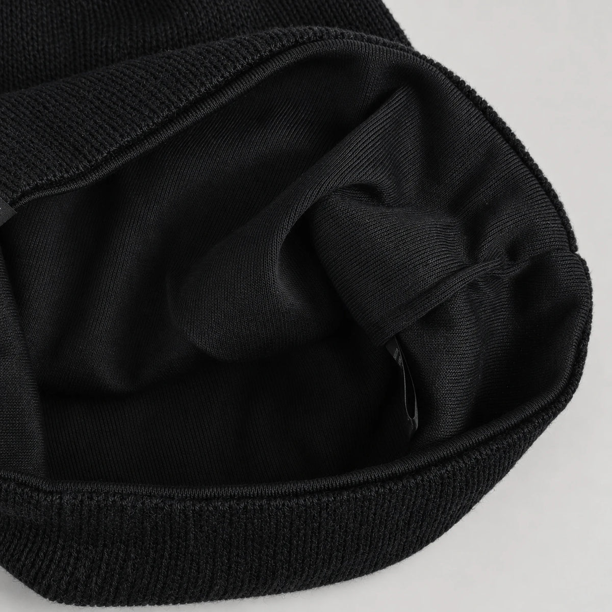 Interior of the black B318 beanie showing the dark fabric lining and stitched opening.