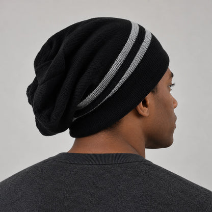 Side-back view of a man wearing the black striped B318 beanie, showing the draped crown.