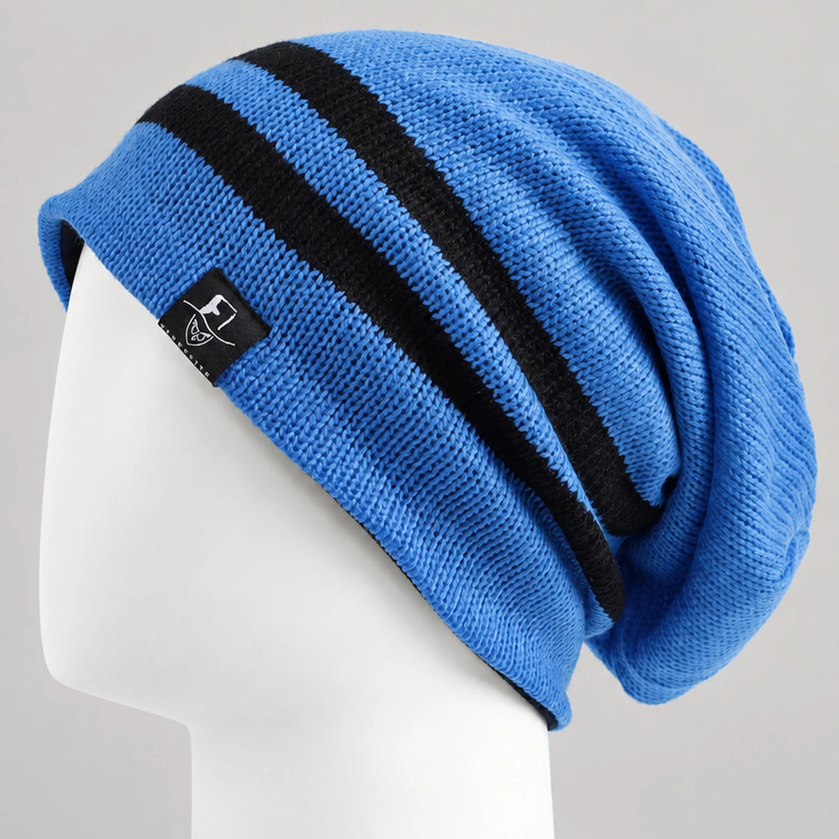 Bright blue slouchy beanie with two black stripes on a white mannequin, side view.