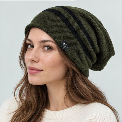 Woman wearing an olive green slouchy beanie with two black stripes and a draped back.