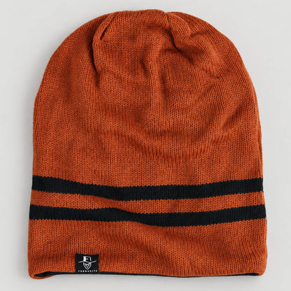 Rust orange B318 beanie laid flat, showing two black stripes near the opening.