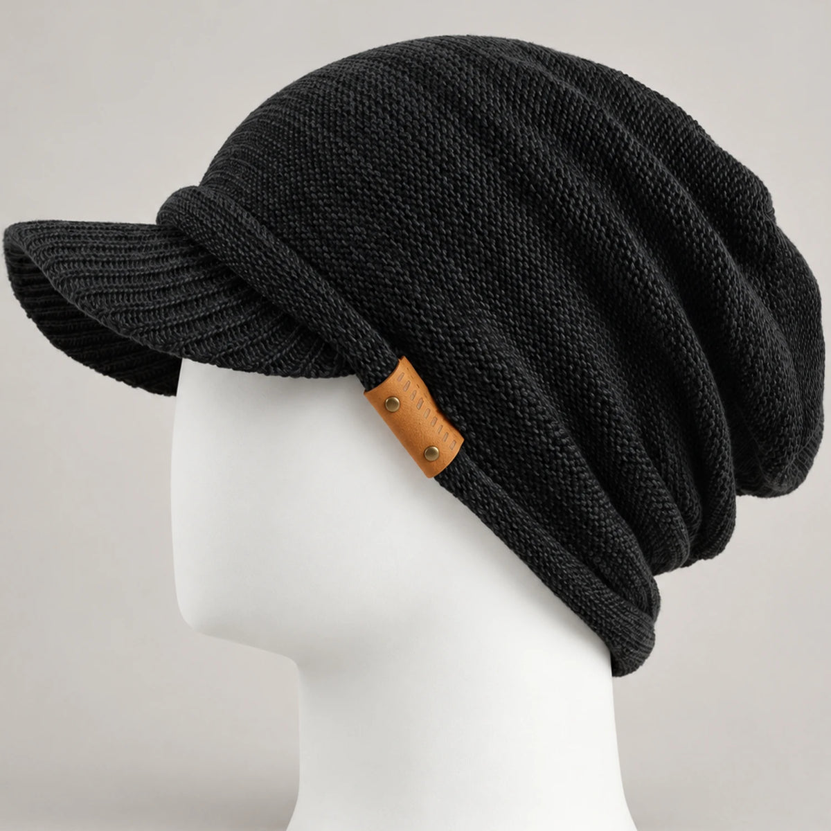 Black knit visor beanie with short brim, leather side detail and relaxed crown