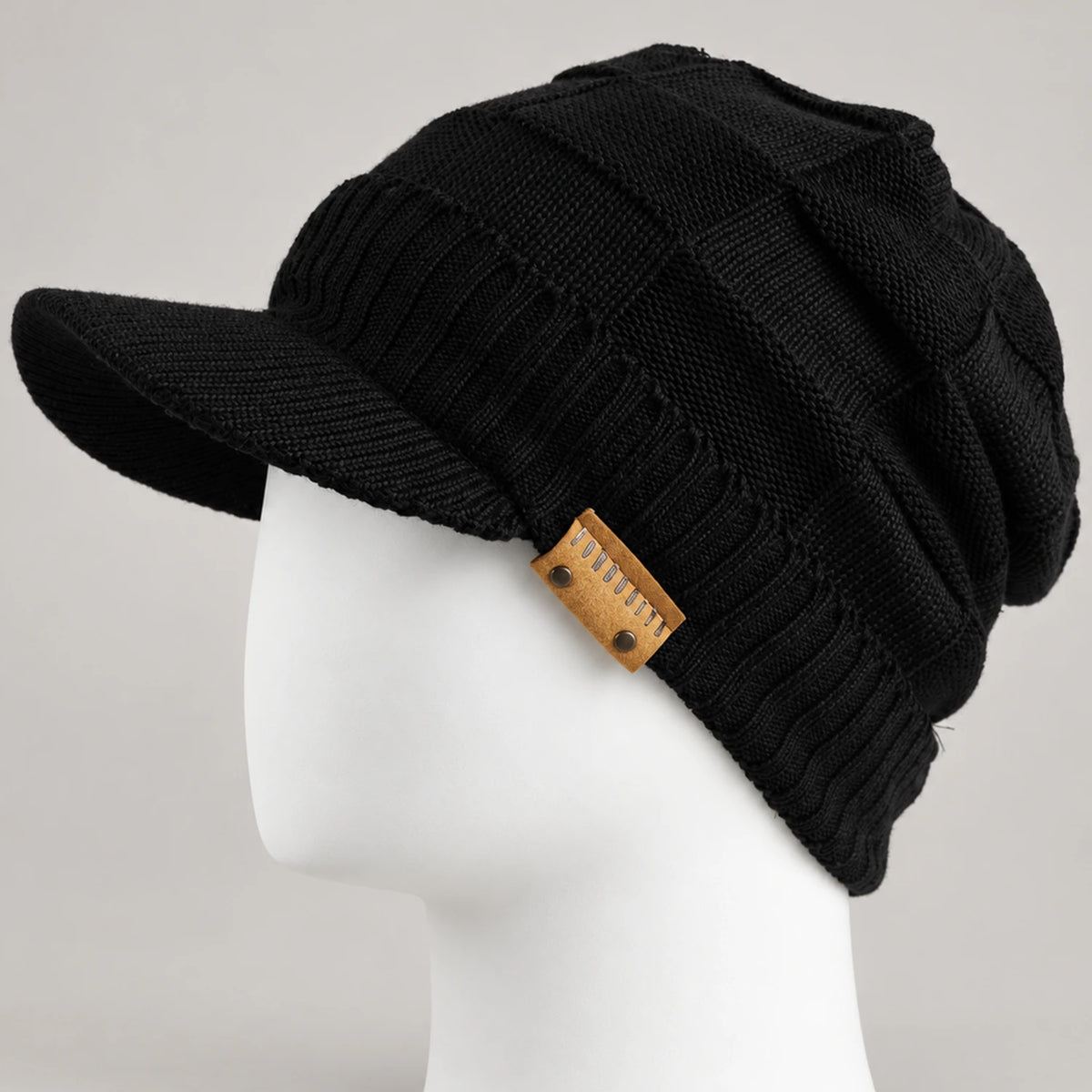 Black knit visor beanie with short brim and textured crown on a mannequin head