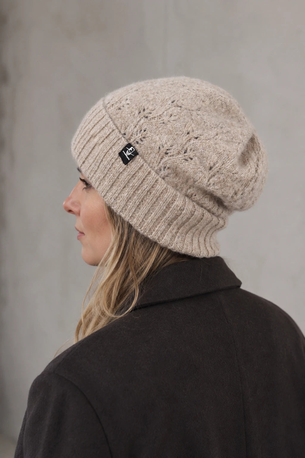 Side view of woman wearing FORBUSITE B5039 oatmeal fuzzy knit beanie with relaxed crown and wide cuff