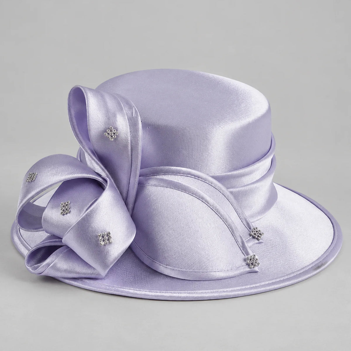 Lavender satin church hat for women with a wide brim, sculptural ribbon bow and small rhinestone accents