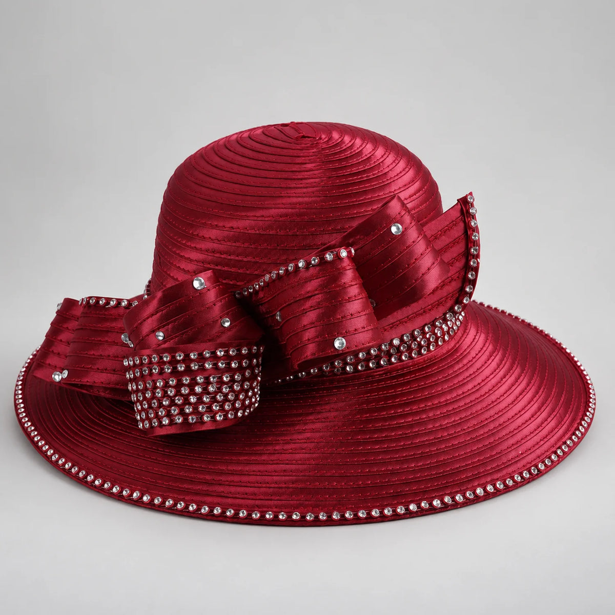 Front view of a burgundy church hat with a layered satin bow, rhinestone accents and a wide brim with sparkling trim