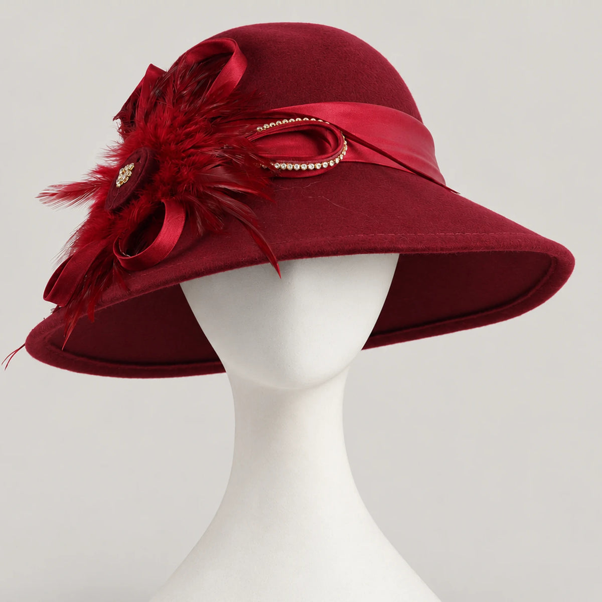 Burgundy feather-trimmed church hat displayed on a white mannequin