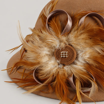 Close-up of the camel hat’s feather decoration, satin ribbon loops and rhinestone detail