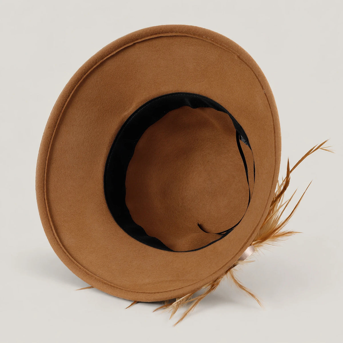 Inside view of the unlined camel wool hat with its black sweatband and adjustment ties