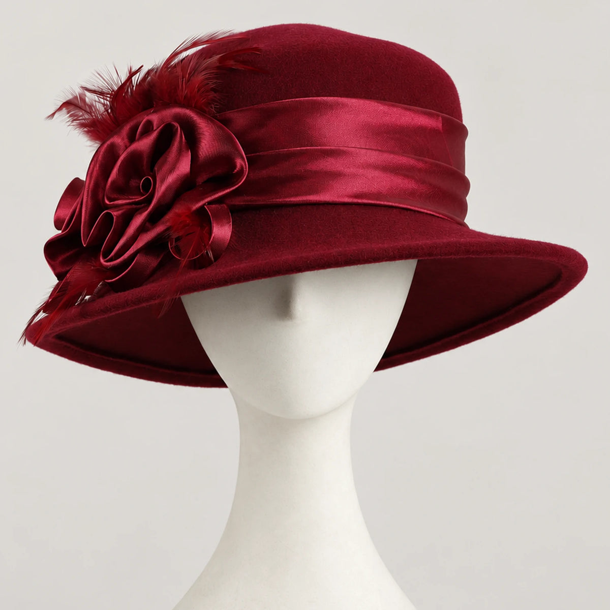 Burgundy Z026H wool church hat with satin ribbon flowers and feathers on a white mannequin