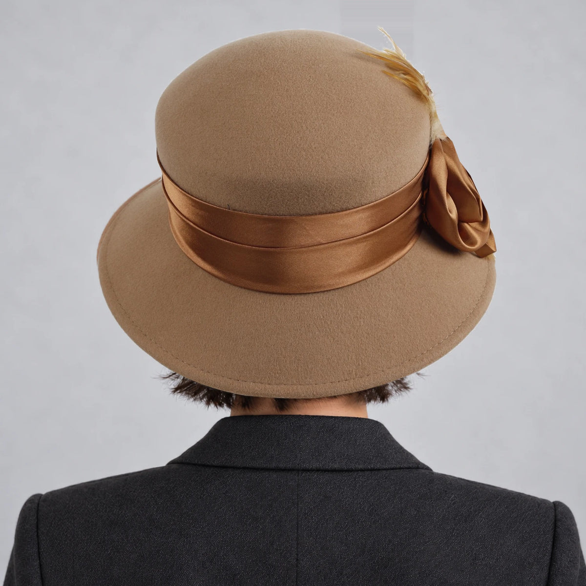 Back view of a woman wearing the camel Z026H hat, showing its ribbon band and crown