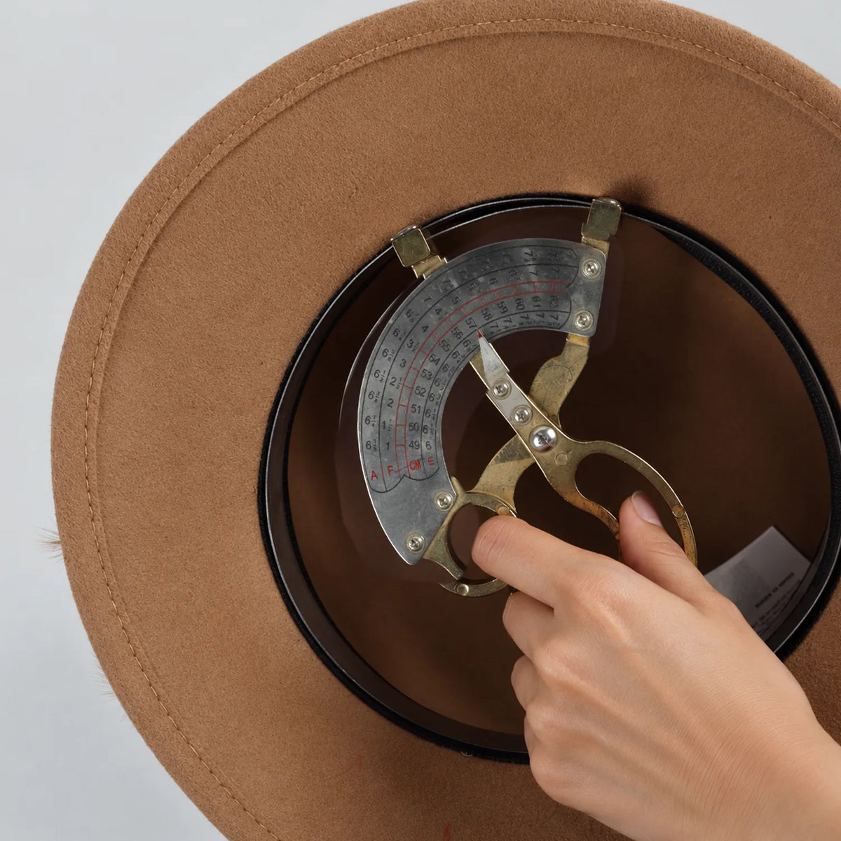 Interior of the camel Z026H hat with a sizing gauge positioned at the sweatband