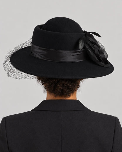 Rear view of the black Z029B hat on a woman, showing its rounded crown and veil behind the brim.
