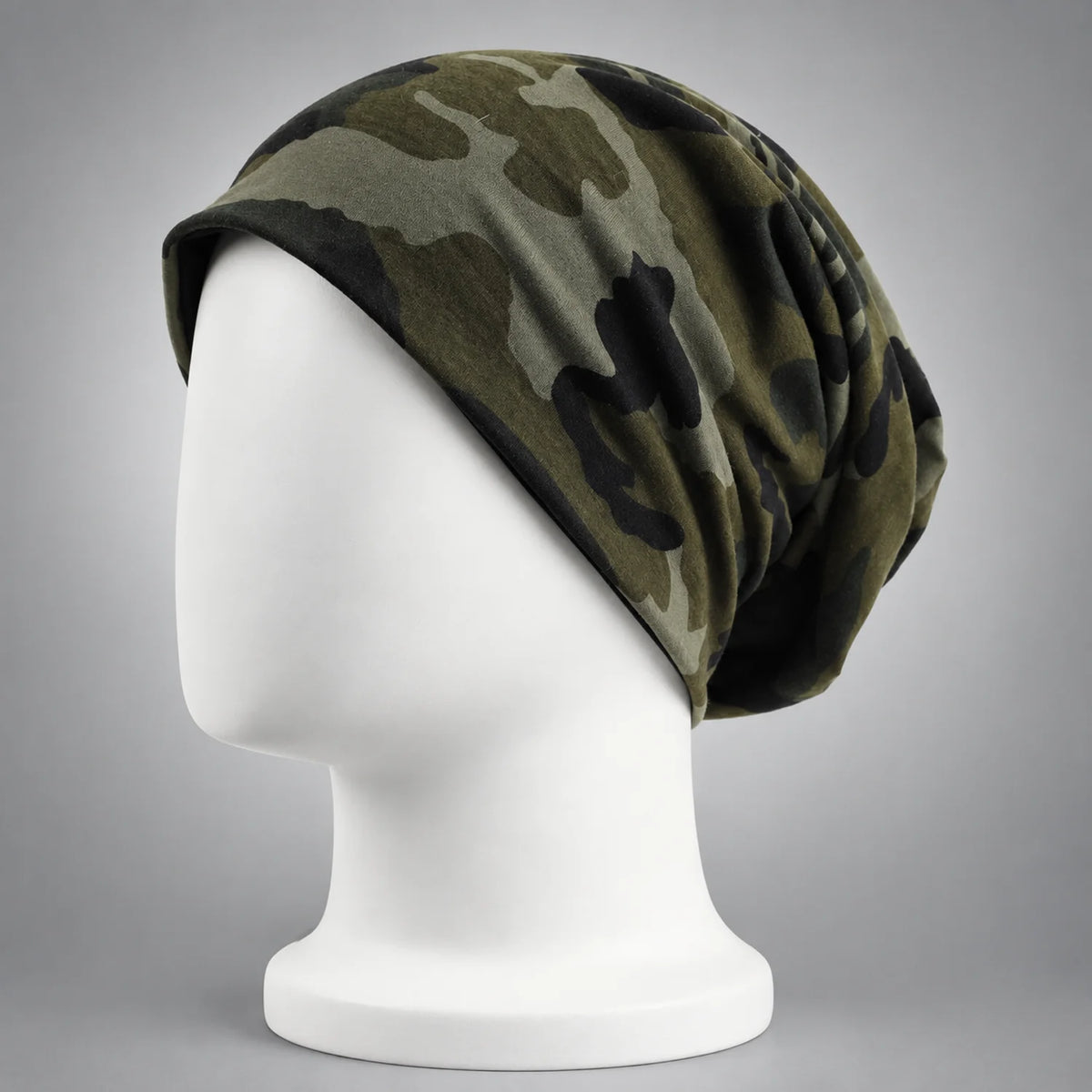 Forest green camo slouchy beanie shown on a white mannequin in side view