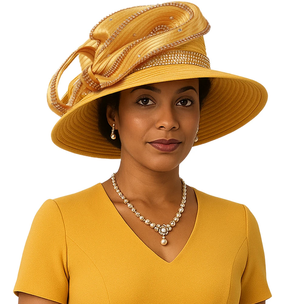 African-American woman wearing a golden yellow rhinestone-trimmed church hat with a sculptural bow design, matching mustard A-line dress, and pearl necklace and earrings, posing against a white background.