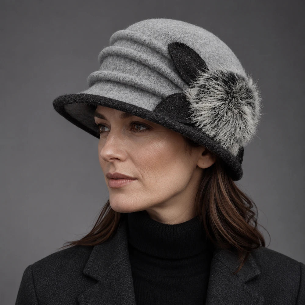 Woman wearing a gray boiled wool cloche hat with a ruched crown and fuzzy pom