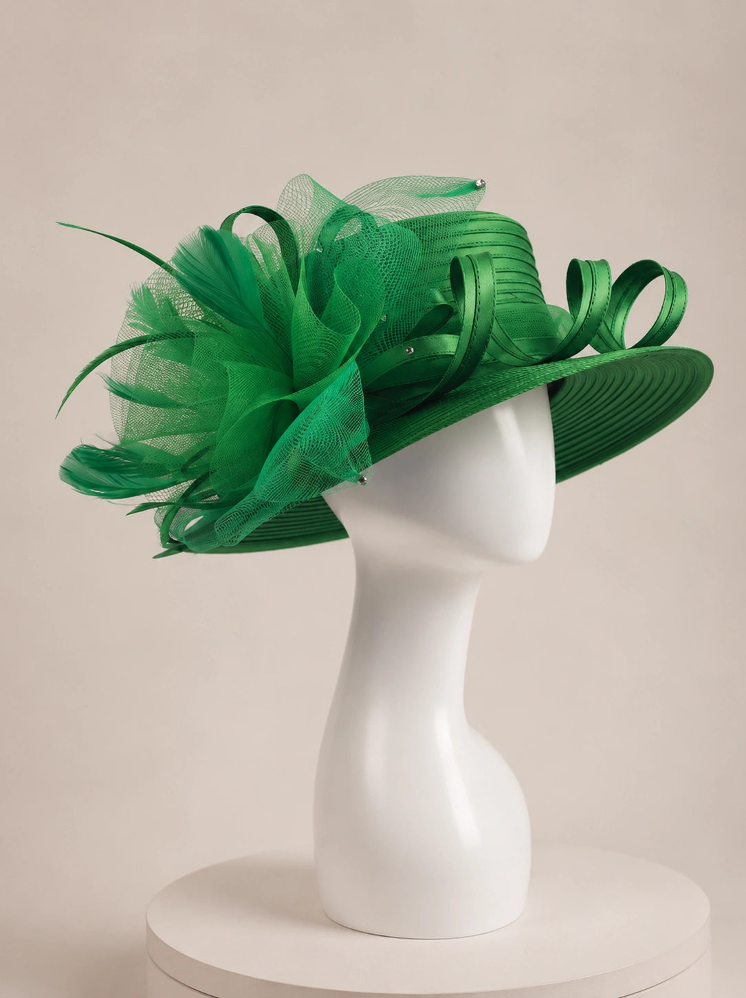 Side view of emerald green wide brim church hat on mannequin with decorative mesh flower and ribbon loops, elegant formal women’s hat